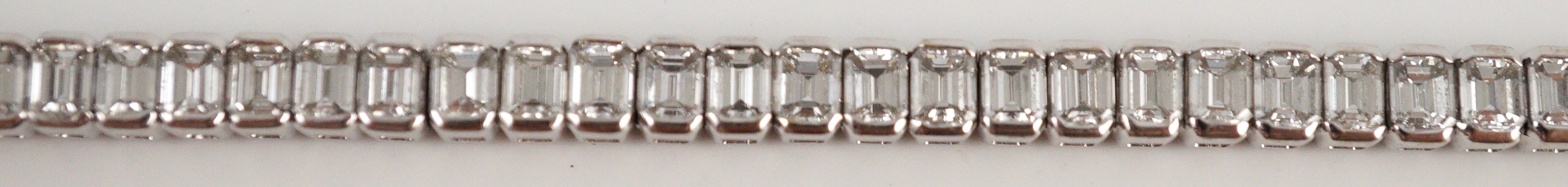 A modern 18ct white gold and emerald cut diamond set line bracelet